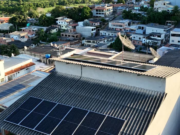 Vista de drone de telhados no meio da cidade, com placas solares instaladas