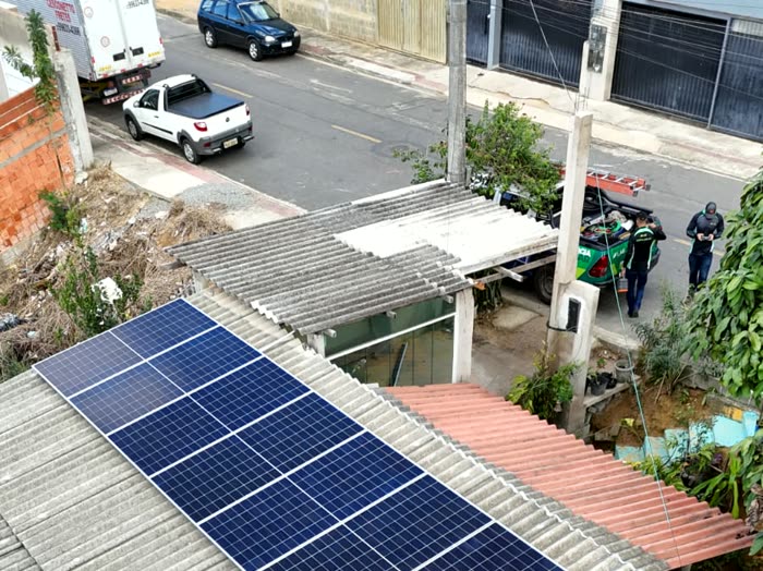 Casa com placas solares recém-instaladas, com o caminhão da obra ainda na rua