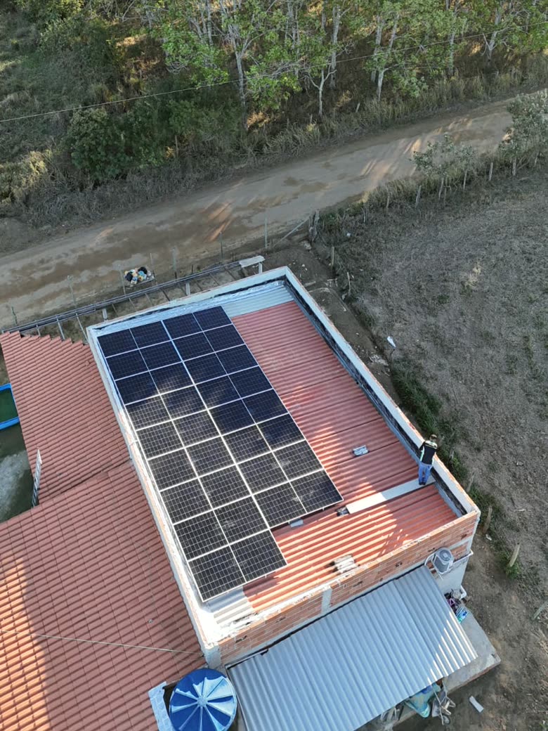 Vista de cima de uma casa com telhado de telha vermelha coberto por placas solares instaladas pela W.U